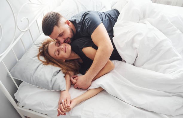 Cute young couple lying down on the bed and sleeping together.